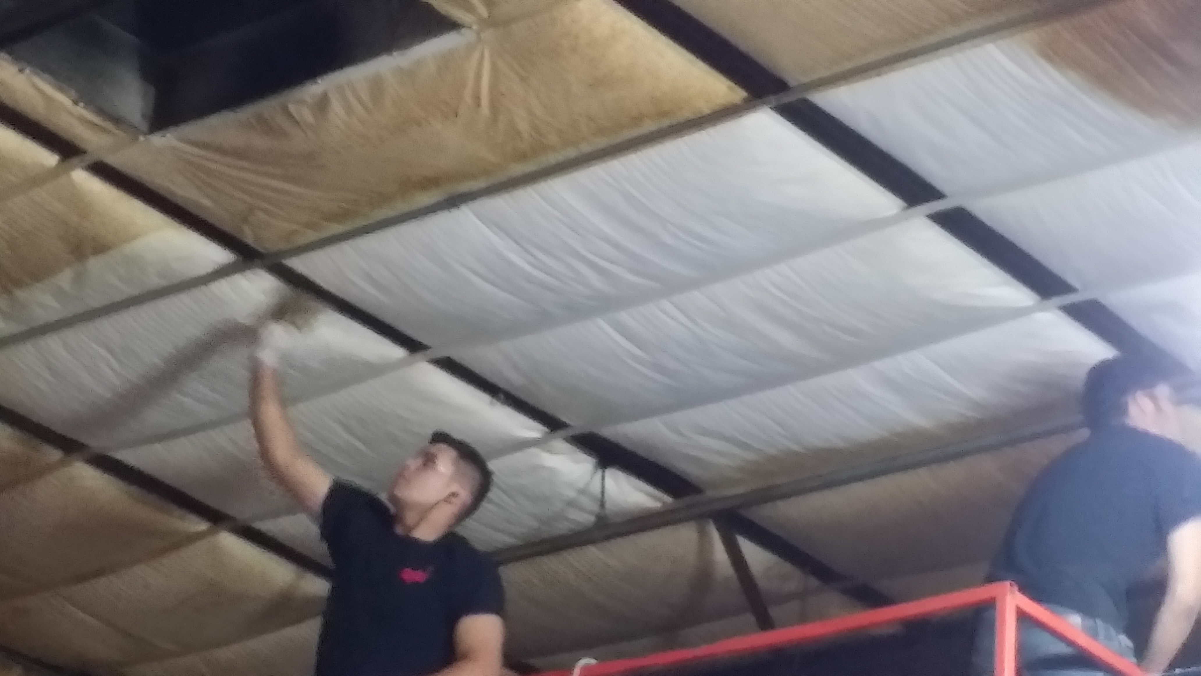 Technicians using plastic containment sheeting during overhead cleaning work